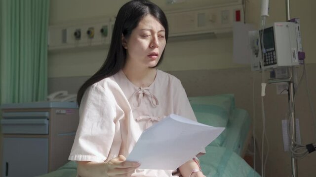 japanese female patient taking glance at the diagnosis and relieve a sigh, looking into distance at a loss. portrait asian woman is upset about getting serious health problem