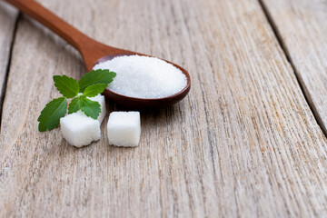 Stevia leaf and white sugar isolated on wood table background. Sweetener concept. 