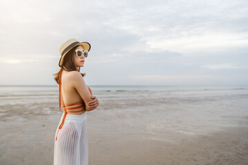 Fototapeta na wymiar woman in bikini standing with arms crossed on sea beach