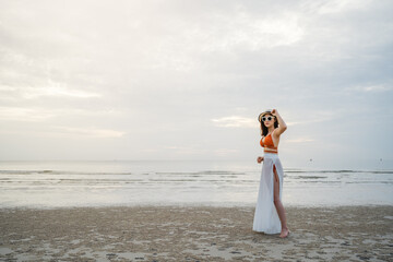 Fototapeta na wymiar cheerful woman in bikini standing at sea beach