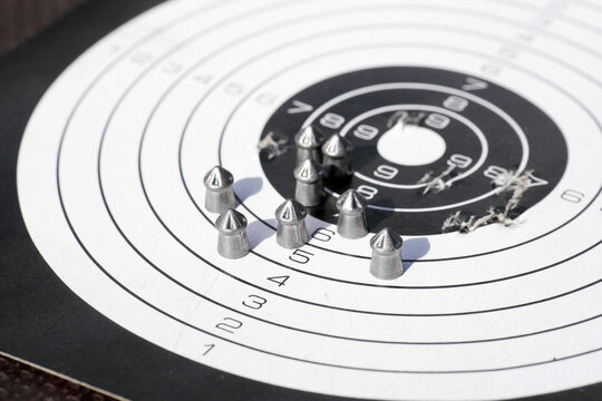 paper shooting target with bullet holes and airgun pellets