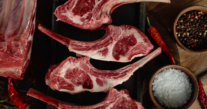 Pieces of raw rack of lamb with chilli and spices rotates.