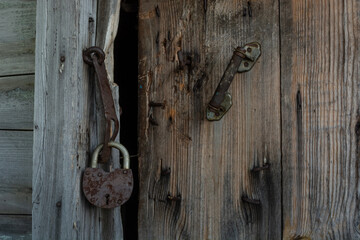 an old rotten wooden door with a broken lock