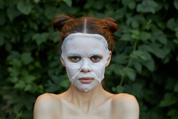 Nice woman face mask Front view clean skin cosmetology bushes in the background