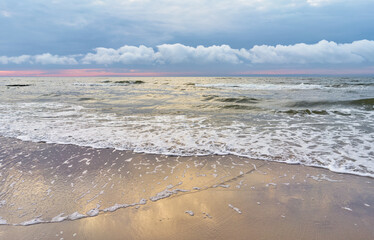 Obraz premium Baltic sea with water waves and sunset sky.