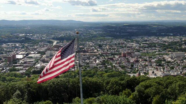 Quintessential Anytown, American city under USA flag, patriotic Memorial Day, July 4th, establishing shot urban United States, diversity inclusion population growth theme, multicultural Reading PA