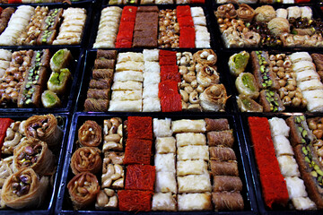 Oriental sweets made from nuts, honey and dough of different shapes and colors. Handmade Oriental sweets at the market in Jerusalem. Market, SHUK Mahane Yehuda with fresh baklava counter in Jerusalem,