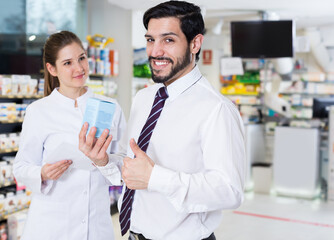 Obraz premium Nice male client is satisfied of recommended medicine in apothecary