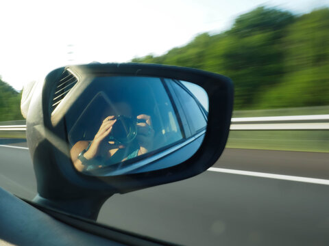 young woman taking a picture of a rearview