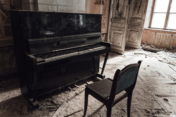 Old broken piano and chair in abandoned ruined mansion. Haunted house interior concept.