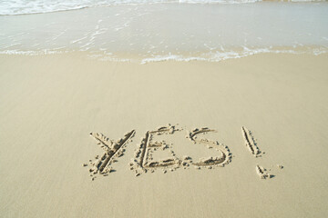 YES concept, word written on sand beach