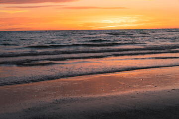 waves rolling in on the shore of beach on gulf of mexico in Southwest Florida during a warm sunset 