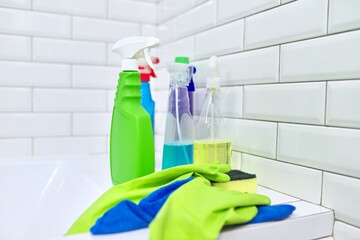 Detergents rag gloves on the background of white tiled wall, copy space