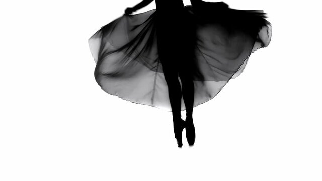 Silhouette of ballerina spinning on pointe isolated on white 