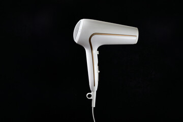 Professional stylish hairdryer isolated over a black background. White Ionic Hair Dryer with Hair Care Tool. Modern Blow Dryer.