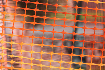 Close-up of an orange plastic mesh. Temporary fence for renovation work
