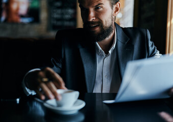 business man sitting at a table in a cafe documents work official coffee cup 