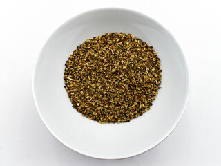 Dried Oregano in a bowl isolated on white background. Top view
