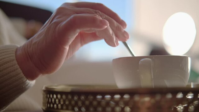 Shot from the side: female pensioner is resting over a cup of coffee.