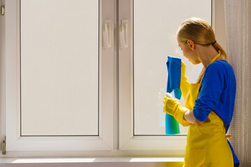 Woman cleaning window at home