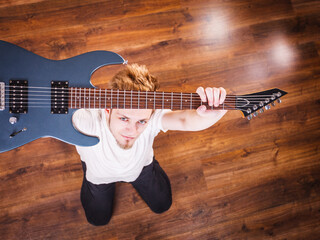 Proud man raising his electric guitar
