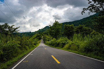 Countryside road passing through the serene lush greenery and foliage tropical rain forest mountain landscape on the Doi Phuka Mountain reserved national park the northern Thailand