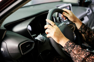 Fototapeta na wymiar Close-up of woman driving, she testing new car in salon