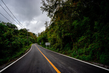 Countryside road passing through the serene lush greenery and foliage tropical rain forest mountain landscape on the Doi Phuka Mountain reserved national park the northern Thailand