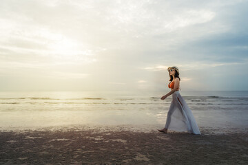 cheerful woman in bikini walking on sea beach