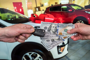 businessman purchase new car in showroom giving dollars money and taking keys from car