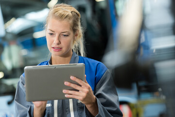 portrait of female factory worker using digital tablet