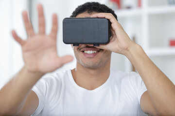 young man smiling on face while testing vr mask