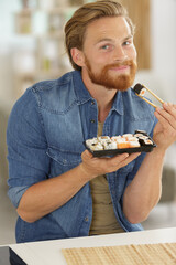 man holding a platter of sushi