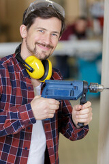 Fototapeta na wymiar portrait of smiling young man holding power drill
