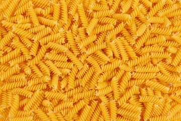 Uncooked fusilli pasta background. Close up of raw fusilli pasta - obrazy, fototapety, plakaty