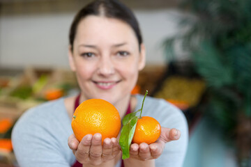 portrait of a happy vendor holding orange varieties