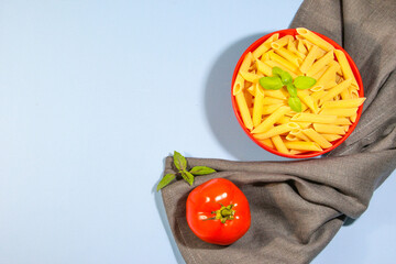 Pasta and ingredients for cooking on blue background, top view. Italian food concept. Pasta,...
