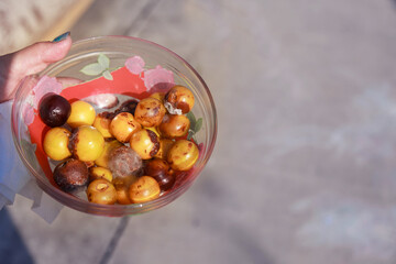 crop failure: spoiled plums in a glass Cup. seasonal goods.