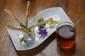 Salty sticks and iced tea served on the restaurant table.