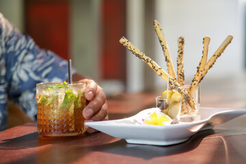 Salty sticks and iced tea served on the restaurant table.