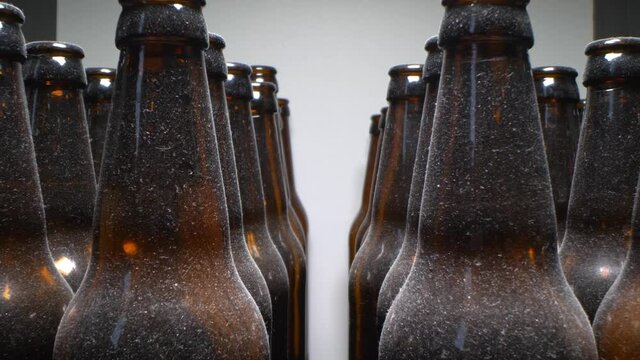 super close up, rows of empty dusty brown glass bottles