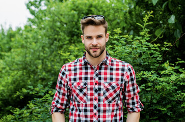 Naklejka na ściany i meble he got great style. casual style clothing. smiling man wear checkered shirt and sunglasses. summer vacation concept. handsome man with bristle outdoor. male fashion and beauty. sexy bearded macho