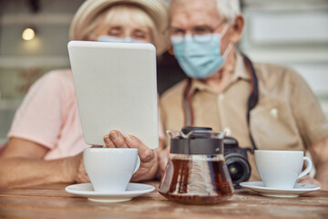 Pensioners staring at a tablet computer in a woman hand