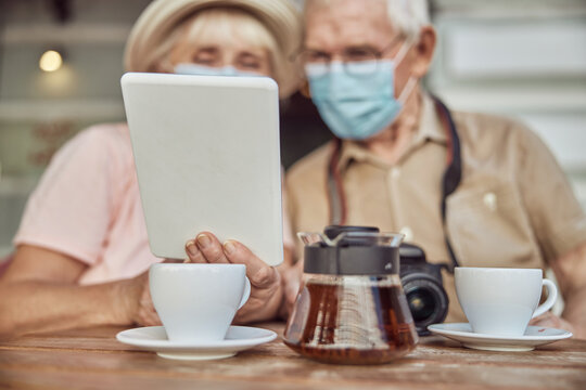 Pensioners staring at a tablet computer in a woman hand