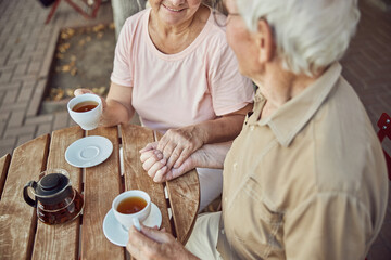 Aged married couple sitting in a street cafe