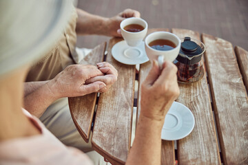 Fototapeta na wymiar Senior couple drinking tea at a wooden table outdoors