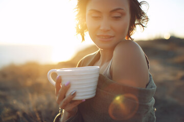 Beautiful woman drinks coffee. Woman outdoors. High quality photo.