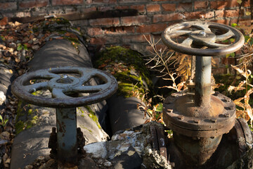 Old rusty valve close up on greenery background.