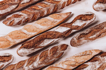 Various types of Bakery bread - fresh rustic crusty loaves of bread and baguette on white background.  (top view, flat lay).
