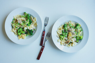 delicious italian vegetarian pasta served in white plate. Broccoli, mushrooms, green beans pasta in creamy sauce